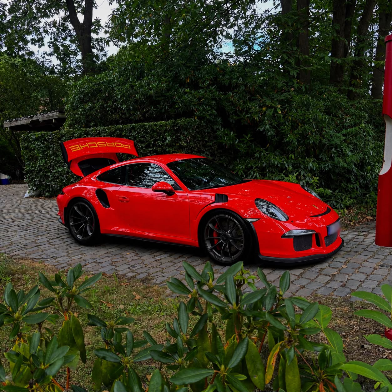 Rode Porsche 911 GT3 RS op een kasseien oprit